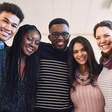 Five young adults smile for the camera