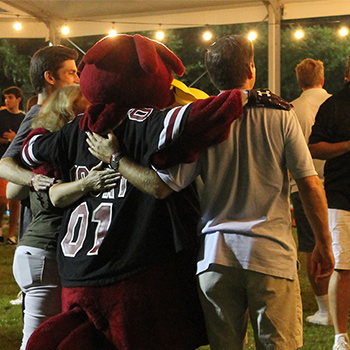 Family posing with Cocky at a family weekend event.