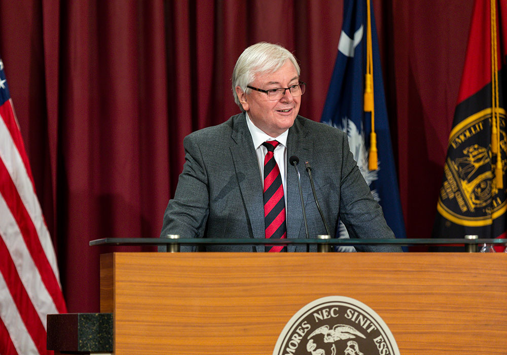 President Michael Amiridis giving a speech at a podium. 