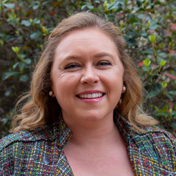 woman smiling outside with paid jacket on