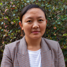 woman smiling outside with plaid jacket on