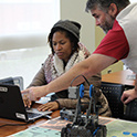 one teacher helps another on laptop