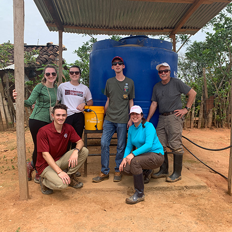 CEC students stand around a water cooler in Ecuador