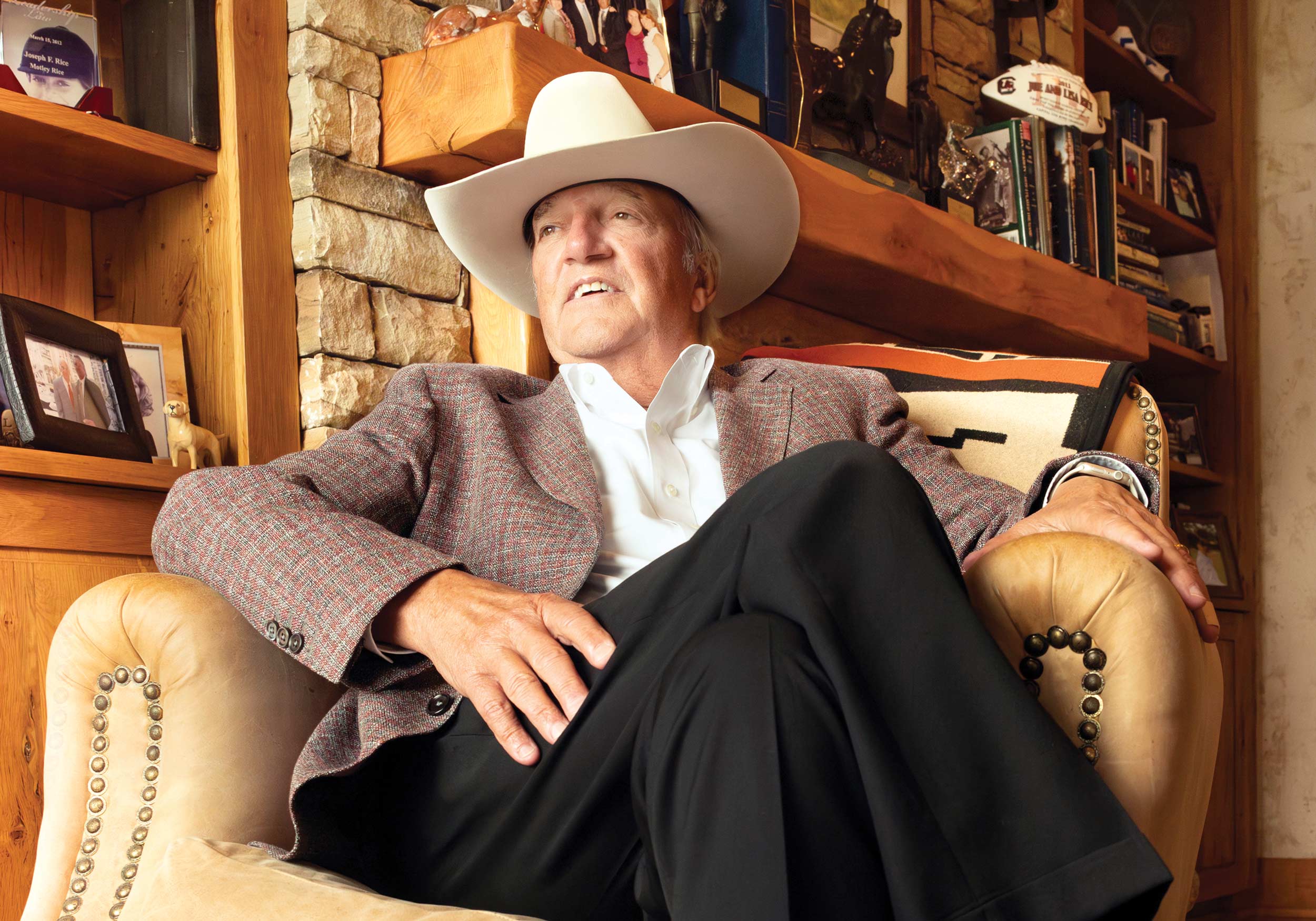 Joe Rice sits in his home office with cowboy hat atop his head.