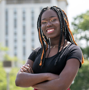 Fatou Diedhiou smiles with Capstone House in the background