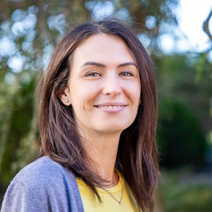 A headshot of Alessandra Porcu standing outside with her head turned toward the camera