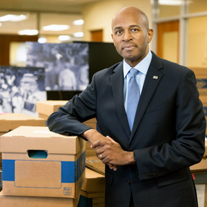 Bobby Donalds leans on a large stack of document boxes.