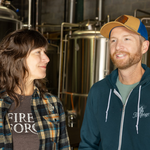 two people stand in front of beer vats